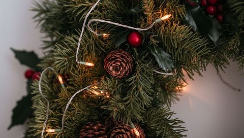 Glowing Evergreen Wreath with Pine Cones and Warm Lights for Cozy Holiday Decor