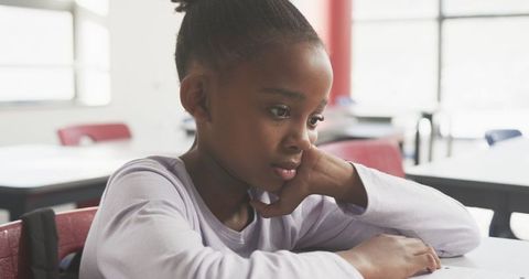 Young student focusing on workbook at school desk