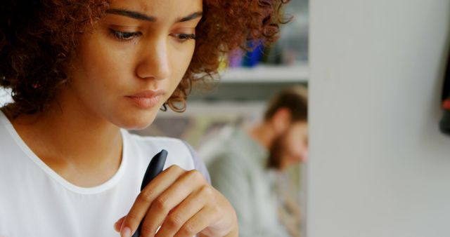 Thoughtful Woman Holding Pen in Office Environment - Download Free Stock Images Pikwizard.com