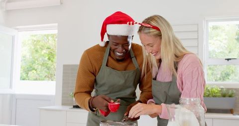 Cheerful couple baking together in festive kitchen