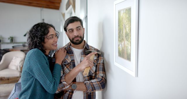 Happy Couple Hanging Artwork on Wall at Home - Download Free Stock Images Pikwizard.com