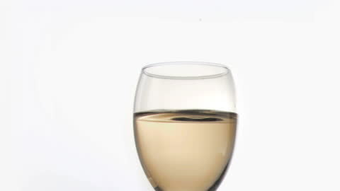 Wine Drop Falling Slow Motion in Glass on White Background