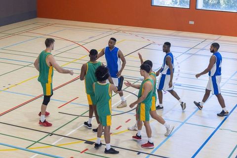 Basketball teams, vibrant intensity, warm handshakes, sportsmanship focused