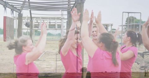 Women High-Fiving on Obstacle Course Showing Team Spirit