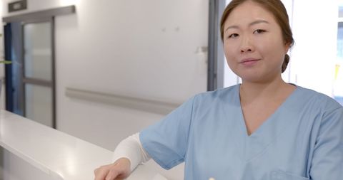 Asian female doctor smiling at hospital reception