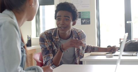 Teenagers Discussing School Projects Together in Classroom