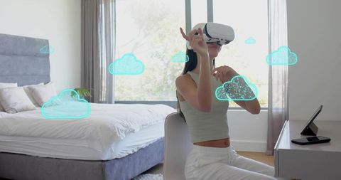 Young woman experiencing virtual cloud interface in sunlit minimalist bedroom