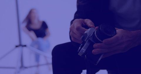 Photographer adjusting camera lens in studio setting