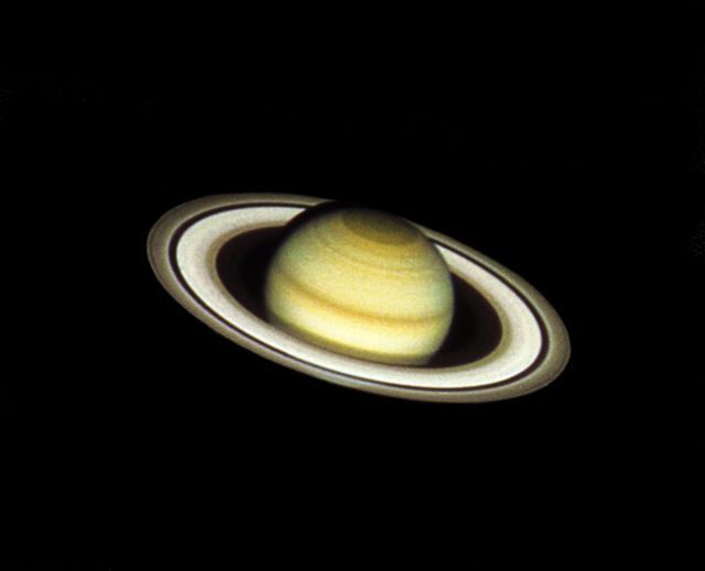 This color image of Saturn was taken with the Hubble Space Telescope's (HST's) Wide Field Camera (WFC) at 3:25 am EDT, August 26, 1990, when the planet was at a distance of 2.39 million km (360 million miles) from Earth. The color in the image is reconstructed by combining three different pictures, taken in blue, green and red light (4390, 5470 and 7180 angstroms). Because Saturn's north pole is currently tilted toward Earth (24 degrees), the HST image reveals unprecedented detail in atmospheric features at the northern polar hood, a region not extensively imaged by the Voyager space probes. The classic features of Saturn's vast ring system are also clearly seen from outer to irner edge; the bright A and B rings, divided by the Cassini division, and the very faint inner C ring. The Enche division, a dark gap near the outer edge of the A ring, has never before been photographed from Earth.