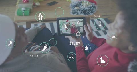 Multigenerational family holding tablet viewing augmented reality holiday icons on couch