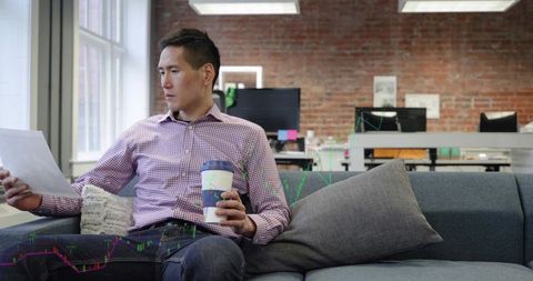 Business Professional Analyzing Documents in Cozy Office Lounge