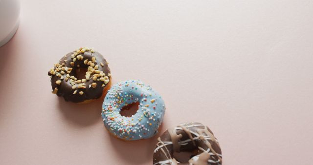 Image of donuts with icing and cup of coffee on pink background. colourful fun food, candy, snacks and sweets concept.