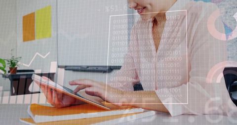Smiling professional woman tapping tablet and analyzing digital data overlays at desk