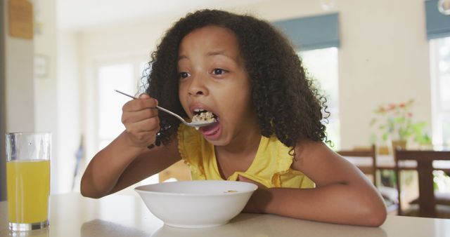 Young Girl Eating Breakfast Cereal in Kitchen - Download Free Stock Images Pikwizard.com