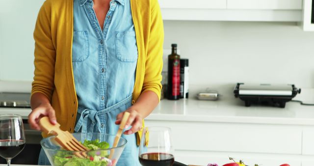 Caucasian Woman Mixing Fresh Salad in Sunny Home Kitchen, Promoting Healthy Lifestyle - Download Free Stock Images Pikwizard.com