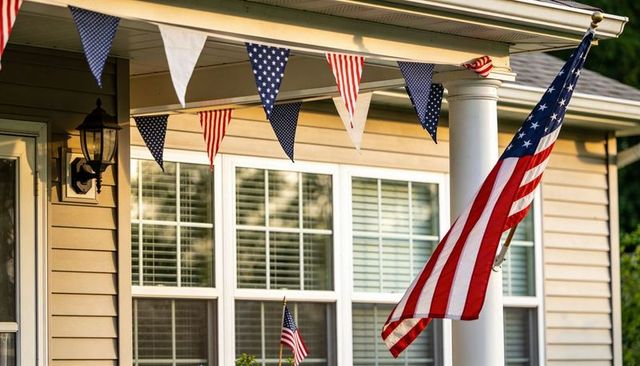 American flag waving on front porch with patriotic red white blue bunting and column summer