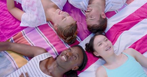 Diverse Friends Enjoying Sunlit Gathering, Relaxation in Park