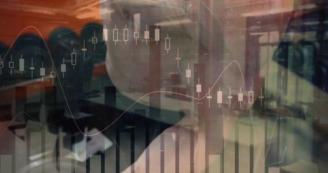 Businessman with glasses analyzing candlestick and line charts on office monitor