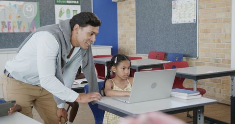 Supportive Male Teacher Assisting Young Student with Laptop - Download Free Stock Images Pikwizard.com