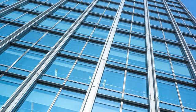 Diagonal Blue Glass Curtain Wall with Reflective Panels and Vertical Metal Mullions Urban Facade