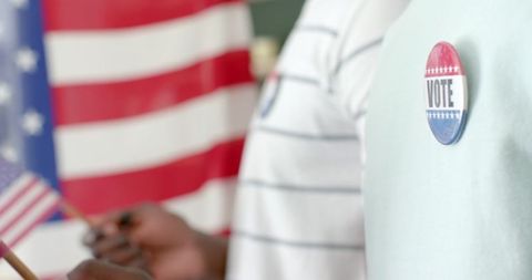 Close-up of voting badge with american flag background