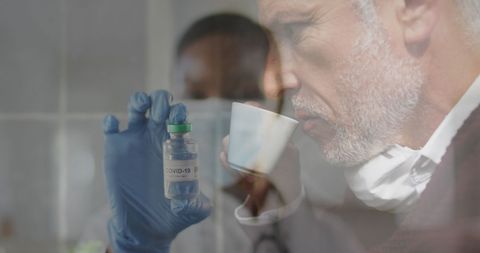 Medical Professional Examining COVID-19 Vaccine Vial With Overlay Senior Man Drinking