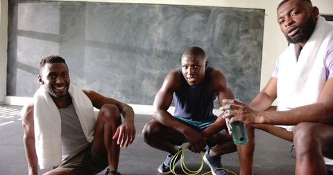 African American Friends Relaxing Post-Workout in Gym Setting
