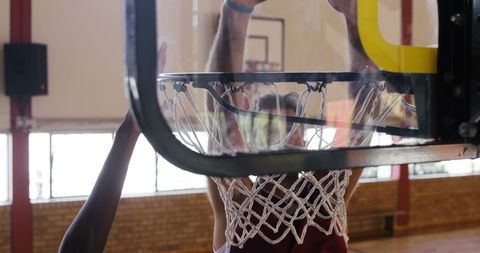 Basketball Player Slam Dunk Seen Through Backboard