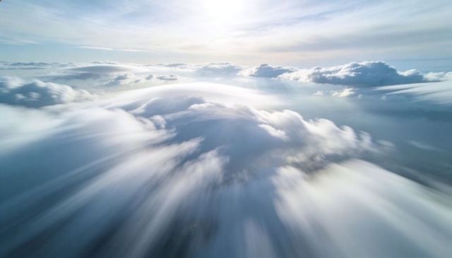 Aerial Radiant Cloud Dome Soaring Above Backlit Cumulus with Sunlit Horizon