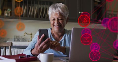 Mature Woman Using Smartphone and Laptop with Digital Icons