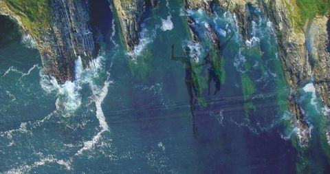 Aerial View of Ocean and Cliffside with Overlay of Couple Running