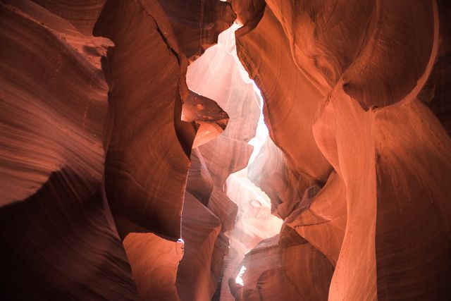 Sandstone canyons lit by sunlight creating dramatic light and shadow patterns. Captures the natural beauty and unique rock formations of Antelope Canyon in Arizona. Ideal for use in travel, nature, and geology content, as well as providing inspiration for outdoor adventure and exploration.