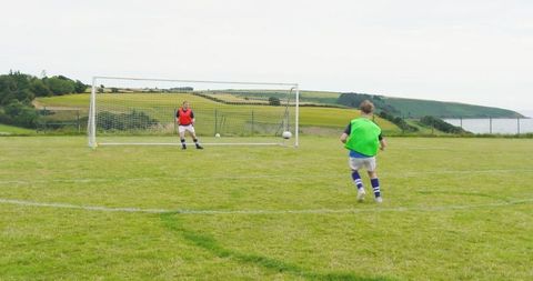 Boys Practicing Soccer on Rural Field During Penalty Training
