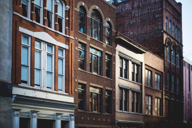 The image showcases a row of historic urban buildings with classic brick facades, highlighting the traditional architecture. The tall structures have large windows, with architectural details reflecting an old city charm. This visual can be used for articles on architecture, historic preservation, urban studies, or city guides.