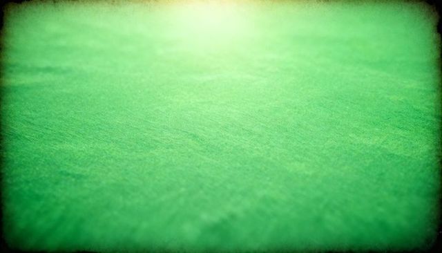 Featuring green felt texture with soft vignette and shallow-focus tabletop backdrop