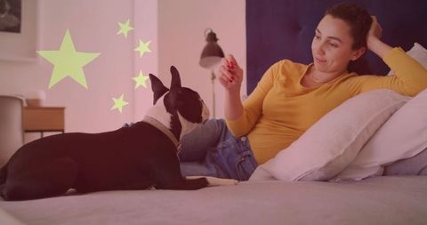 Woman lounging with dog on bed highlighting relaxing lifestyle