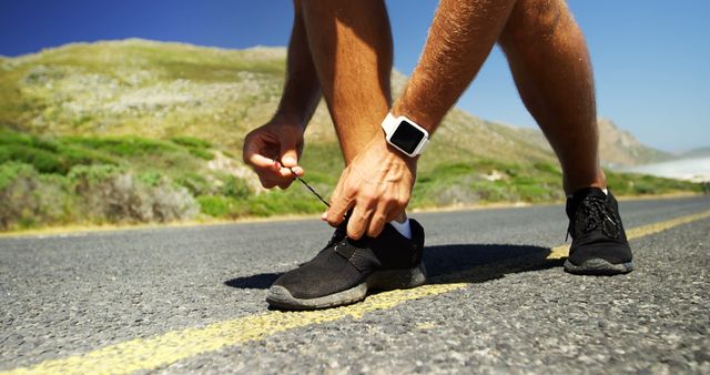 Runner Tying Shoelaces On Roadside Ready For Exercise - Download Free Stock Images Pikwizard.com