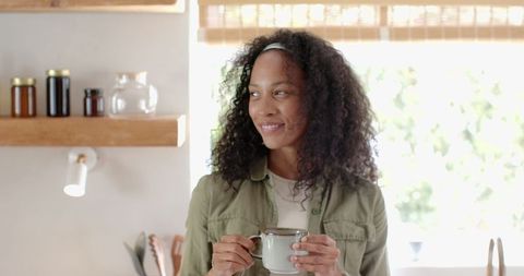 African American Woman Enjoying Coffee in Cozy Home Kitchen