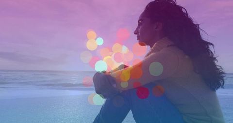 Serene Woman Reflecting on Beach with Bokeh Lights at Dusk
