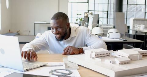 Smiling Professional Engaging with Architectural Projects in Modern Office