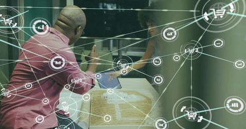 Collaborating over architectural model and laptop with digital network overlay in office