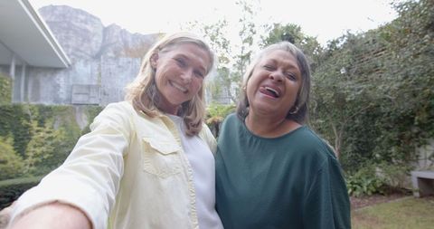 Diverse friends smiling together outdoors for selfie taking