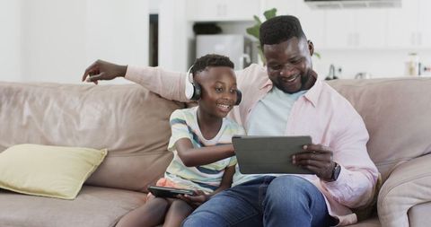 Father and Son Using Digital Tablets in Cozy Home Environment