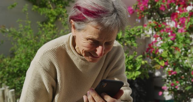 Senior Woman Using Smartphone in Garden on Sunny Afternoon - Download Free Stock Images Pikwizard.com