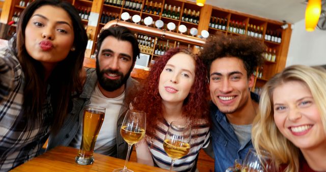 A diverse group of young adults is taking a selfie at a bar, with copy space - Download Free Stock Photos Pikwizard.com