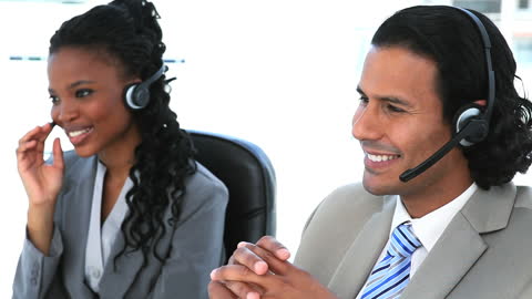 Smiling Customer Service Representatives with Headsets in Office