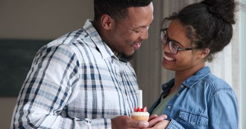 Couple Celebrating Anniversary with Candlelit Cupcake at Home