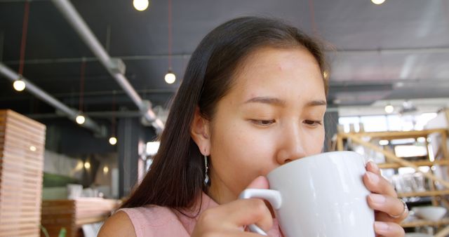 Young Woman Drinking Coffee in Modern Cafe - Download Free Stock Images Pikwizard.com