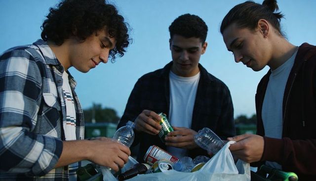 Teen friends sorting recyclables at dusk promoting sustainability and community action