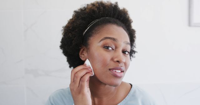 Young Black woman maintaining skincare routine in bathroom - Download Free Stock Images Pikwizard.com